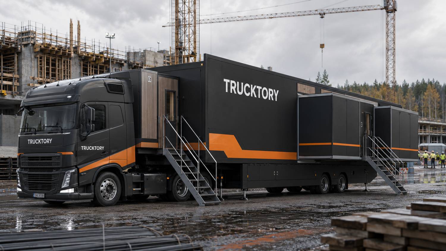 Musta-oranssi Trucktory-rekka rakennustyömaalla, portaat auki ja palvelutilat levitettyinä